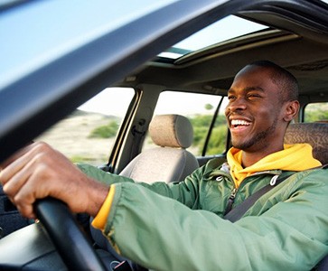 Smiling man drives off