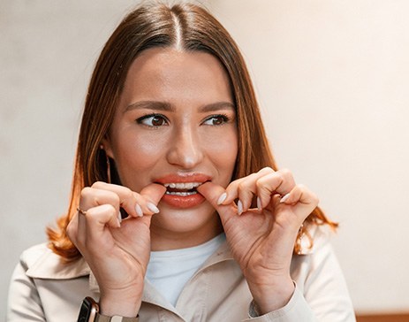 Patient putting on clear aligner in treatment room