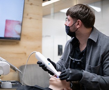 Dentist making digital impressions of patient’s teeth