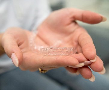 Closeup of patient holding clear aligner