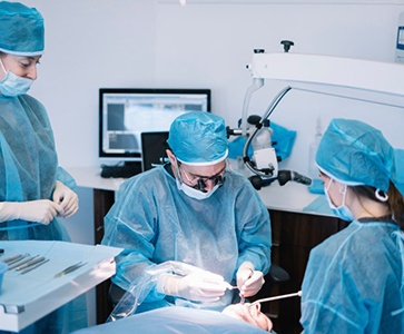 an oral surgeon performing dental implant placement surgery