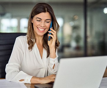 Woman smiling while talking on phone in office