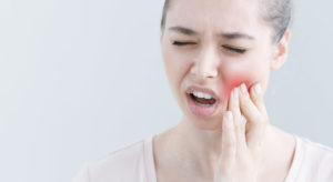 Woman holding jaw in pain