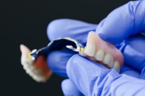 hand holding dental prosthesis