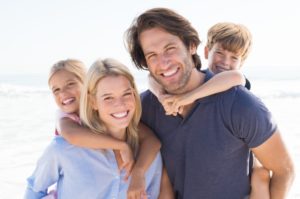 family of four hugging and smiling