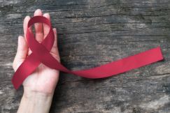 Hand holding a maroon ribbon