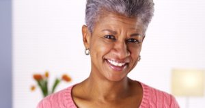 older attractive woman curly grey hair pink shirt