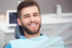 person smiling after having missing back tooth replaced