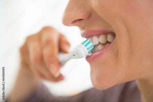 closeup of person brushing teeth